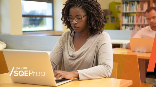 A black woman is seen using a laptop and studying for the SQE. To the bottom left of screen, the "Barbri SQE prep" logo is seen.