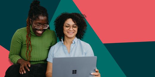 Two black women are seen from the front and smile at a laptop screen, as they think about the pure joy of applying to the Flex Trainee scheme.