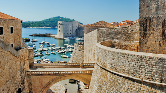 tan stone walls of dubrovnik croatia with view of water