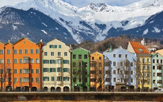 colorful buildings in front of snow capped mountains in innsbruck
