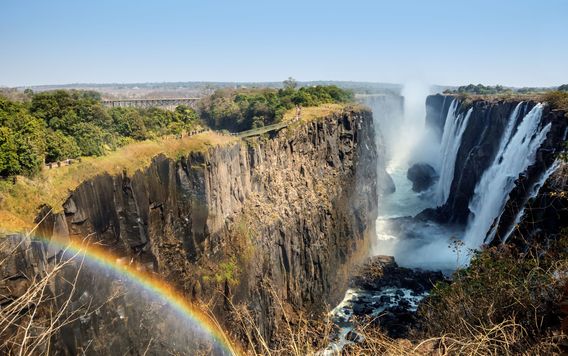 victoria falls with rainbow shining over waterfalls