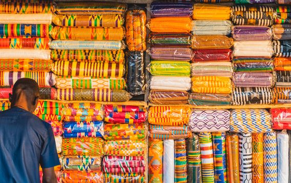 man looking at textiles at a shop in ghana