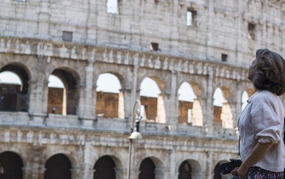female solo traveler looking up at the colosseum in rome italy 