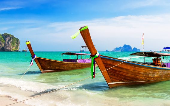 wooden boats docked on the beach off of the phi phi island