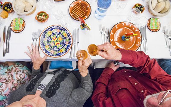 birds eye view of two people cheering with wine at a dinner table
