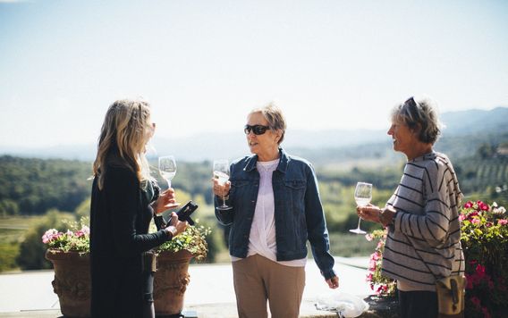 three ladies cheering white wine in tuscany