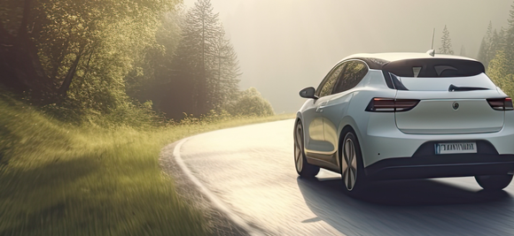 A white car driving on a winding road through a lush, sunlit forest with trees on both sides.