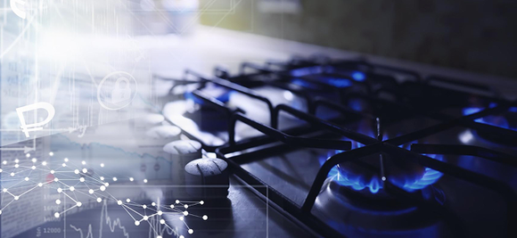 A gas stove burner is lit with a blue flame, overlaid with financial charts and graphs, suggesting a connection between energy use and economics.