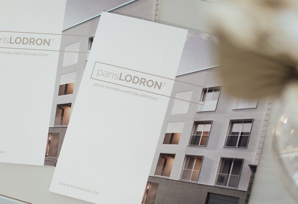 Zwei Folder zur Bauprojekt Wohnzone Paris Lodron 7 liegen auf einem Tisch