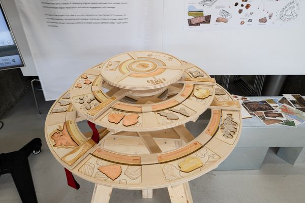 
        Foto der Abschlussarbeit »Table of Curiosities: from Artifacts to living Narratives« von Anna Okhrimenko. Semester: Sommer 2025. Abteilung: Architekturentwurf 2. Werksangabe: Interactive mechanical table with AR elements, booklet, drawings, textile print. Universität für angewandte Kunst Wien.
      