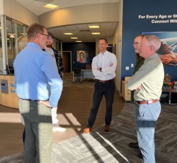 Someone To Tell It To co-founders Tom Kaden (center) and Michael Gingerich (right) talk to guests at a book signing event at the Capital Blue Cross Connect health and wellness center in Enola.