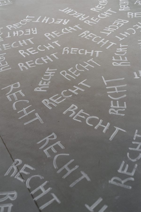 The word ‘Recht’ (in german Law) written with white markers on the floor  | Image by ©