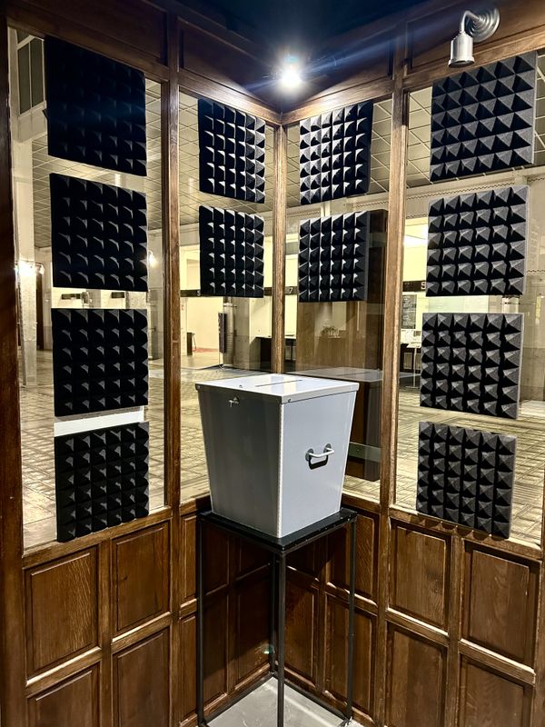 grey voting box standing in wooden cabin in cashier cabin | Image by ©