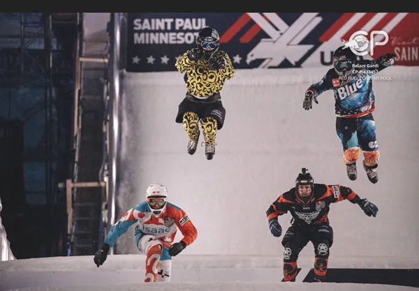 Nathan and 3 other participants on the Crashed Ice track, 2 are in the air mid-jump and 2 are on the ice