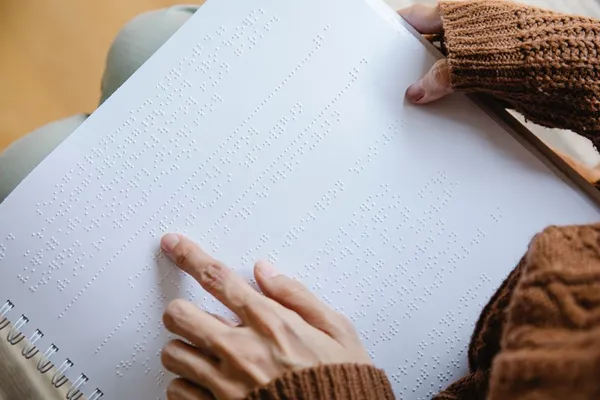 Picture of and hand that is reading braille. 
