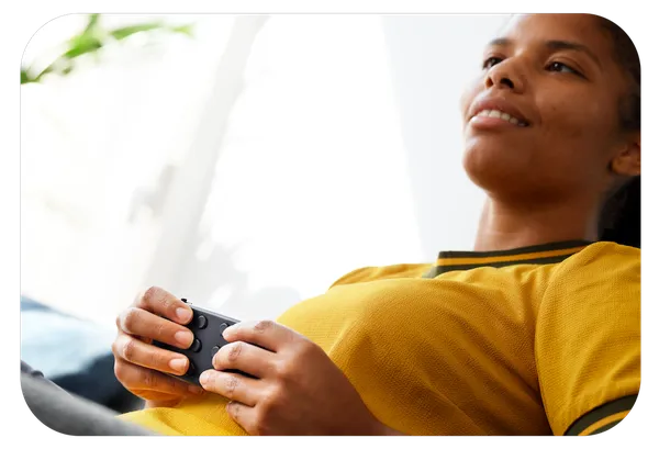 Model using the Hable One while sitting on the couch, wearing a yellow sweater.