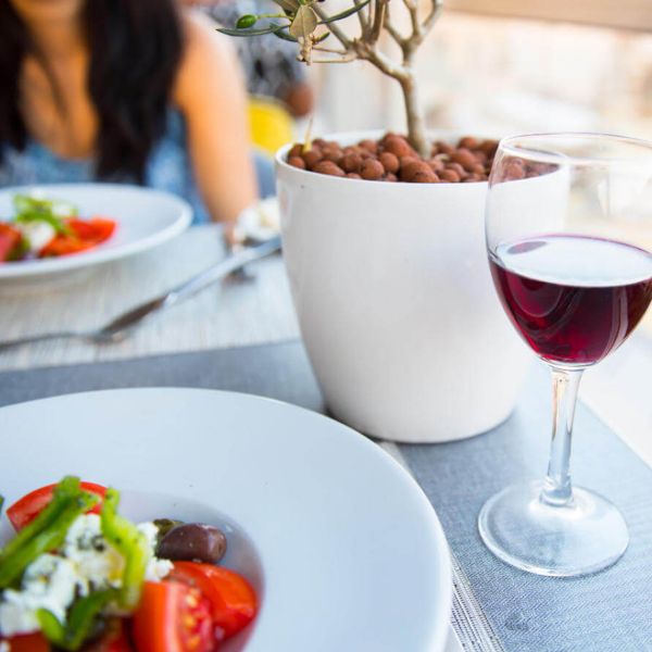 glass of red wine with greek salad