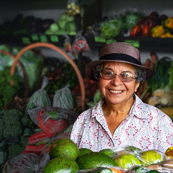a smiling woman selling vegetables in boquete panama