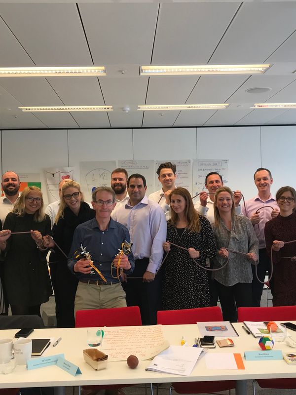 Andy Cave and a group of people who participated in a workshop holding rope