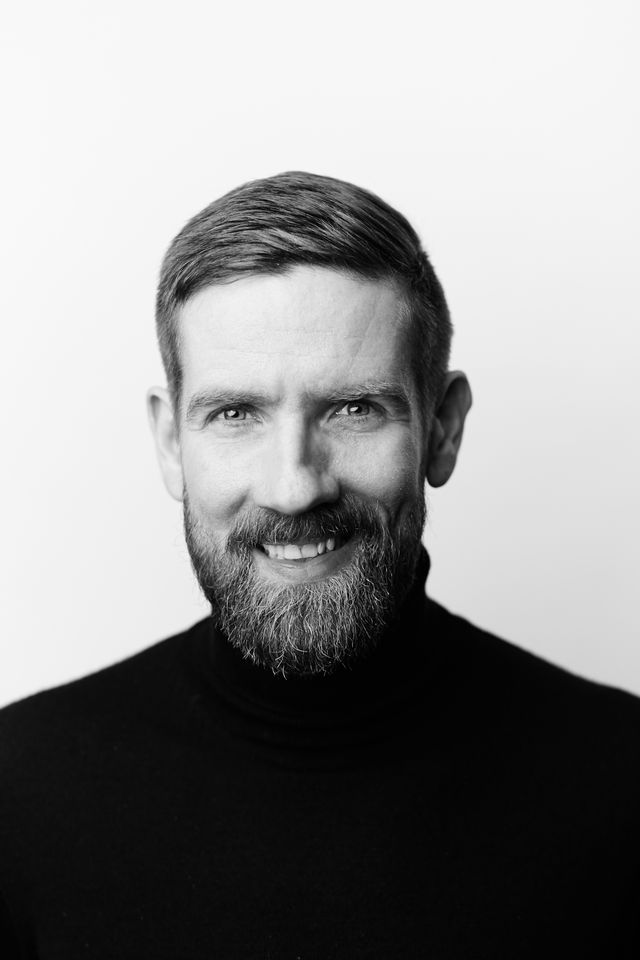 Bewerbungsfoto Mann schwarz weiß Studiolicht lachendes ausdrucksstarkes Portrait