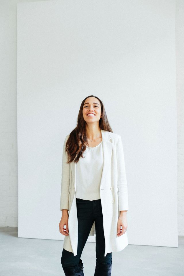 Bewerbungsfoto einer lachenden Frau vor hellem Hintergrund 