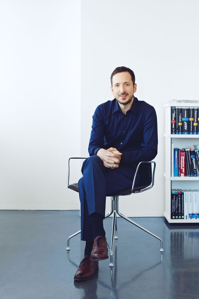 Mann sitzt auf Stuhl Businessportrait Berlin Corporate Fotografie