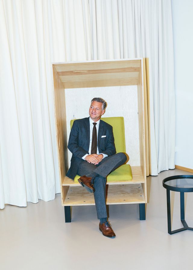 modernes Businessportrait Mann sitzt im Anzug im modernen Sessel