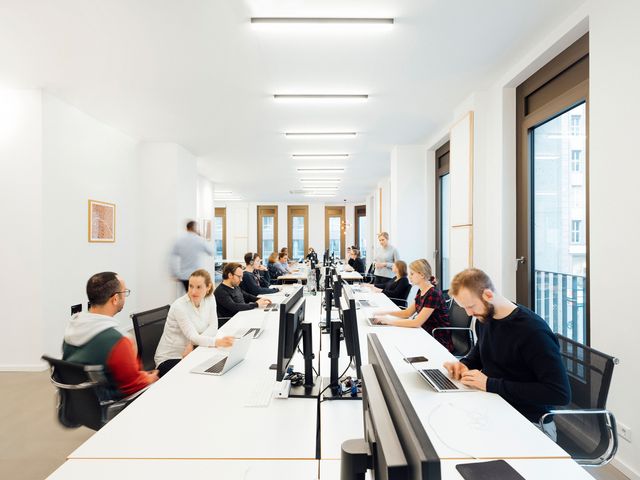 Office Interior Businessfotografie Berlin Mitarbeiter arbeiten an großem Schreibtisch Corporate Fotografie