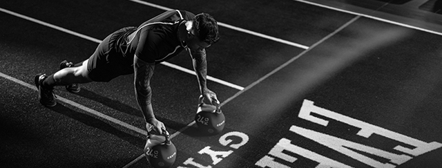 a man doing elevated press ups using Centr kettlebells on Everlast Gyms Perform Turf