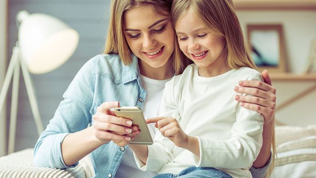 jeune femme avec sa fille regardant l'écran d'un iPhone
