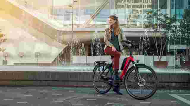 Vrouw op e-bike d-RULE van Sparta voor fontein in de stad