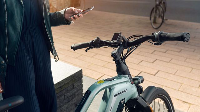 Styret på e-bike d-BURST og kvinde med telefon