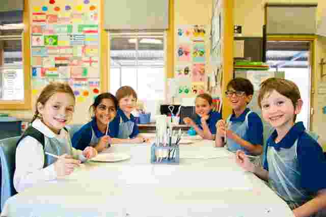 kids smiling while painting together