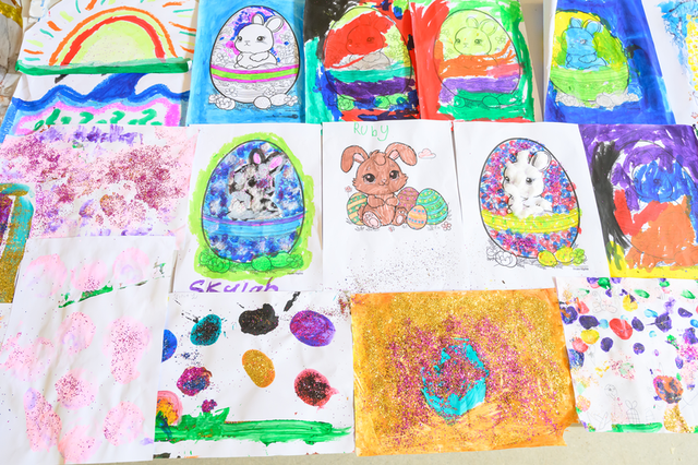 A collection of colorful children's artwork featuring bunnies, Easter eggs, rainbows, and abstract designs, some with glitter.