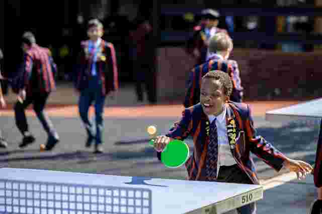 Boys playing table tennis outside