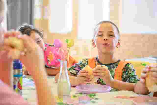 Kids eating fish burgers in service