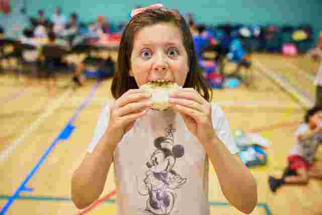 Child having their lunch in a sports hall