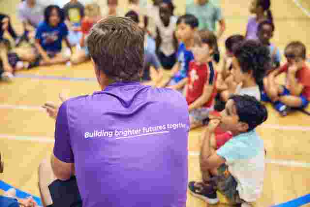 JAG staff and children in a circle in a sports hall
