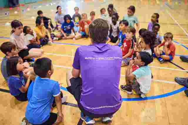 JAG staff and children in a circle in a sports hall