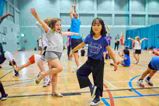 Children dancing in a sports hall