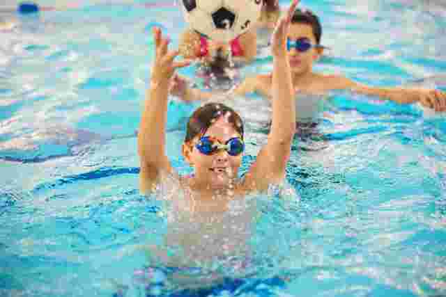 Children playing with a ball in the swimming pool