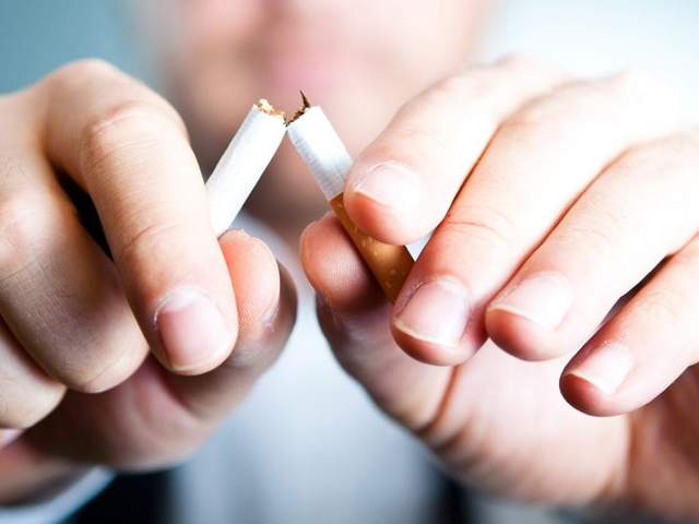 Mann zerbricht Zigarette um Osteoporose-Risikofaktor zu meiden