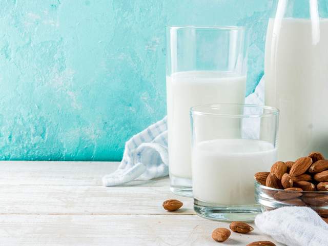 Gläser mit Milch und Nüsse als Beispiel für Calcium-Lieferanten
