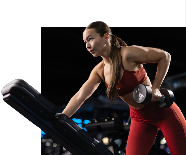 a women lifting free weights on a bench in Myprotein clothing