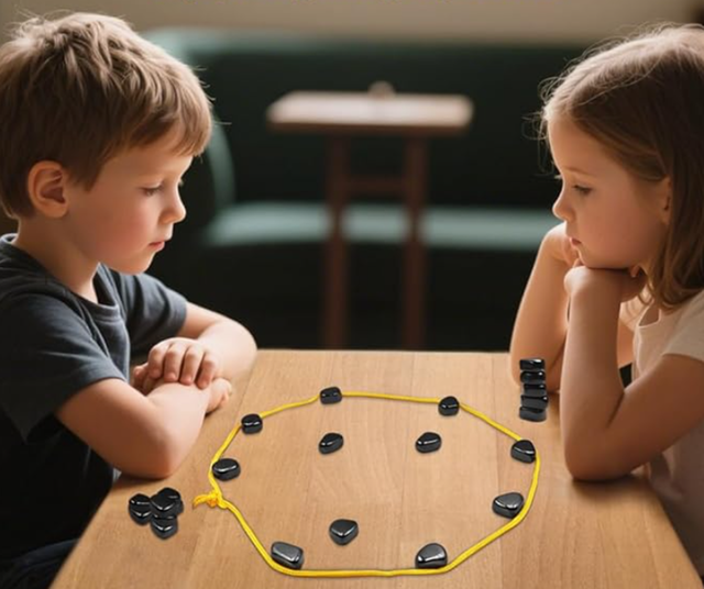 Two children, a boy and a girl, sitting opposite each other playing the viral magnet game