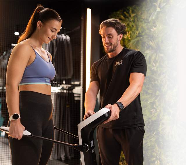 Girl on the inbody machine with a personal trainer talking her through her stats