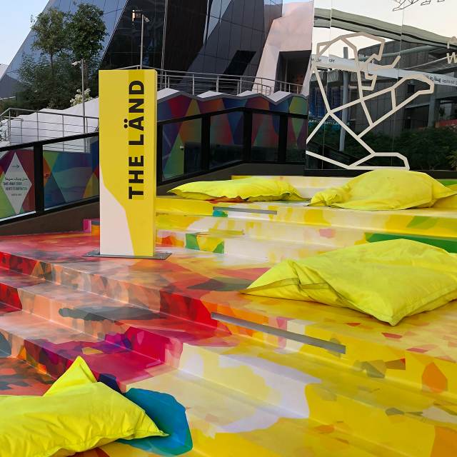 Bunte Treppenstufen mit einem "THE LÄND" Aufsteller darauf.