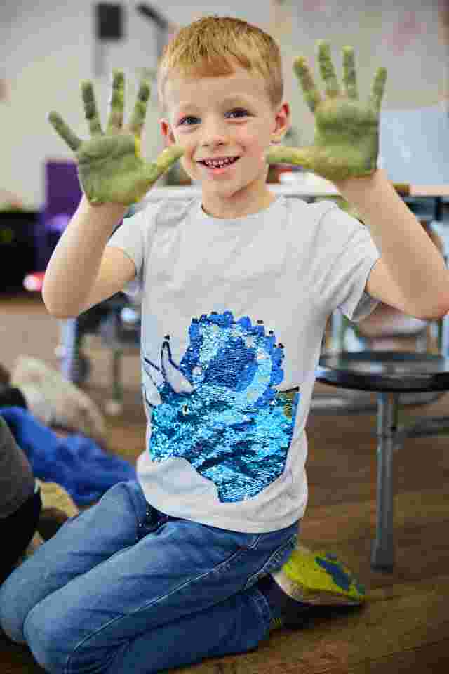 Child hand painting JAG messy play