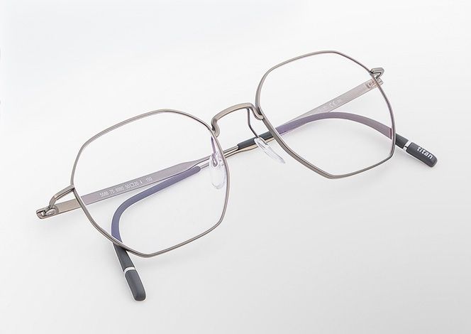 Pure Visionary titanium eyeglasses with an ultra-thin profile wire frame in a soft metallic finish, geometric lenses, a sculpted bridge, and lightweight temples with black temple tips.