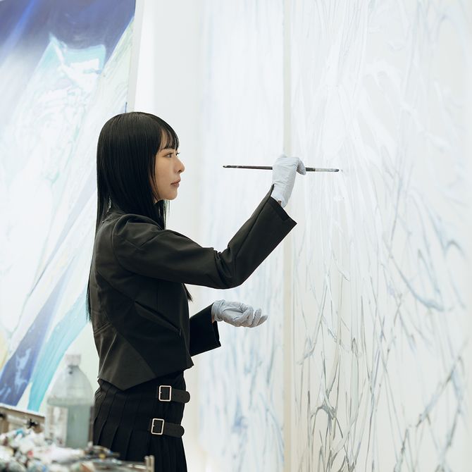 artist Minhee Kim adding details to a painting in her studio
